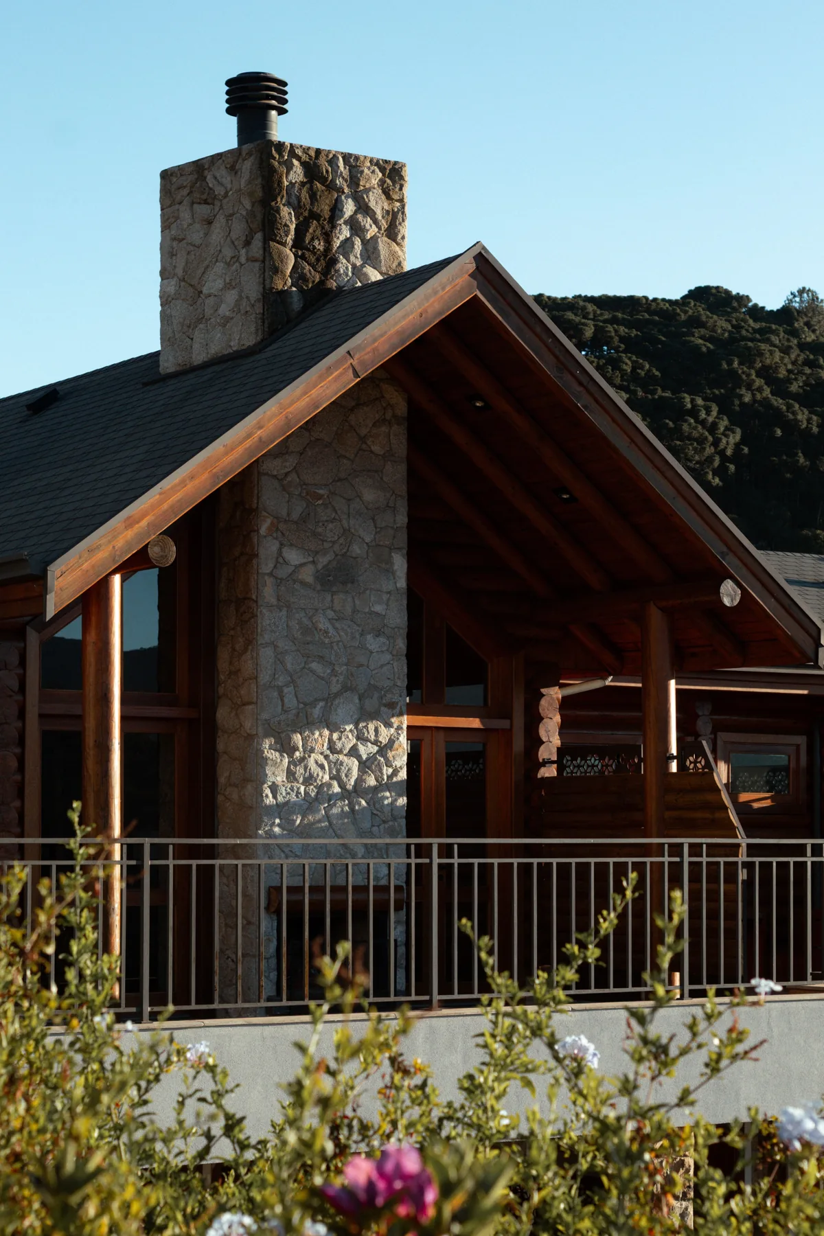 Timber cabin with a stone chimney and a sheltered terrace
